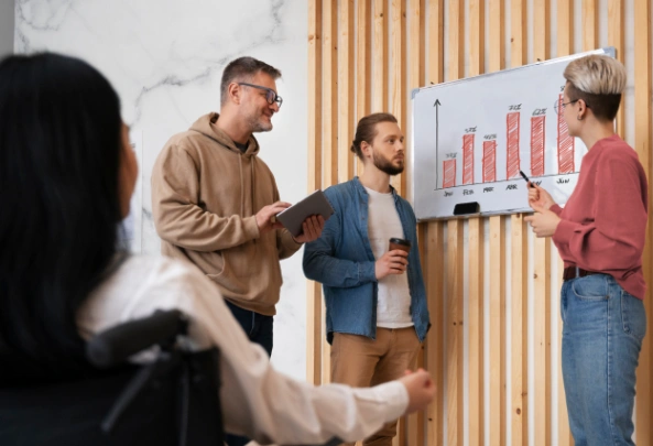 Team of diverse professionals discussing metrics on whiteboard